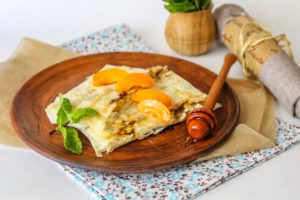 Lavash with cottage cheese, raisins and hard cheese in a frying pan