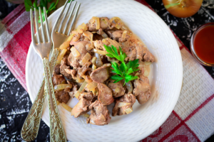 Tender chicken liver with onions in a frying pan